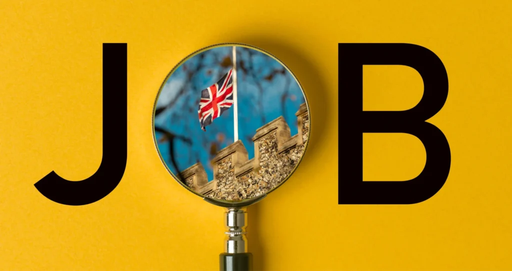 Magnifying glass showing UK flag and building with the word JOB on a yellow background – representing part-time job opportunities for international students in the UK.